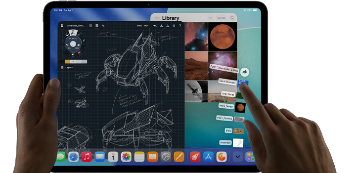 iPad Pro, space black color, left hand holding device, right hand pointing gesturing to manipulate multiple open app windows, a drawing app with sketches of mechanical designs, photos library of planets and space images, downloads folder files fanned out